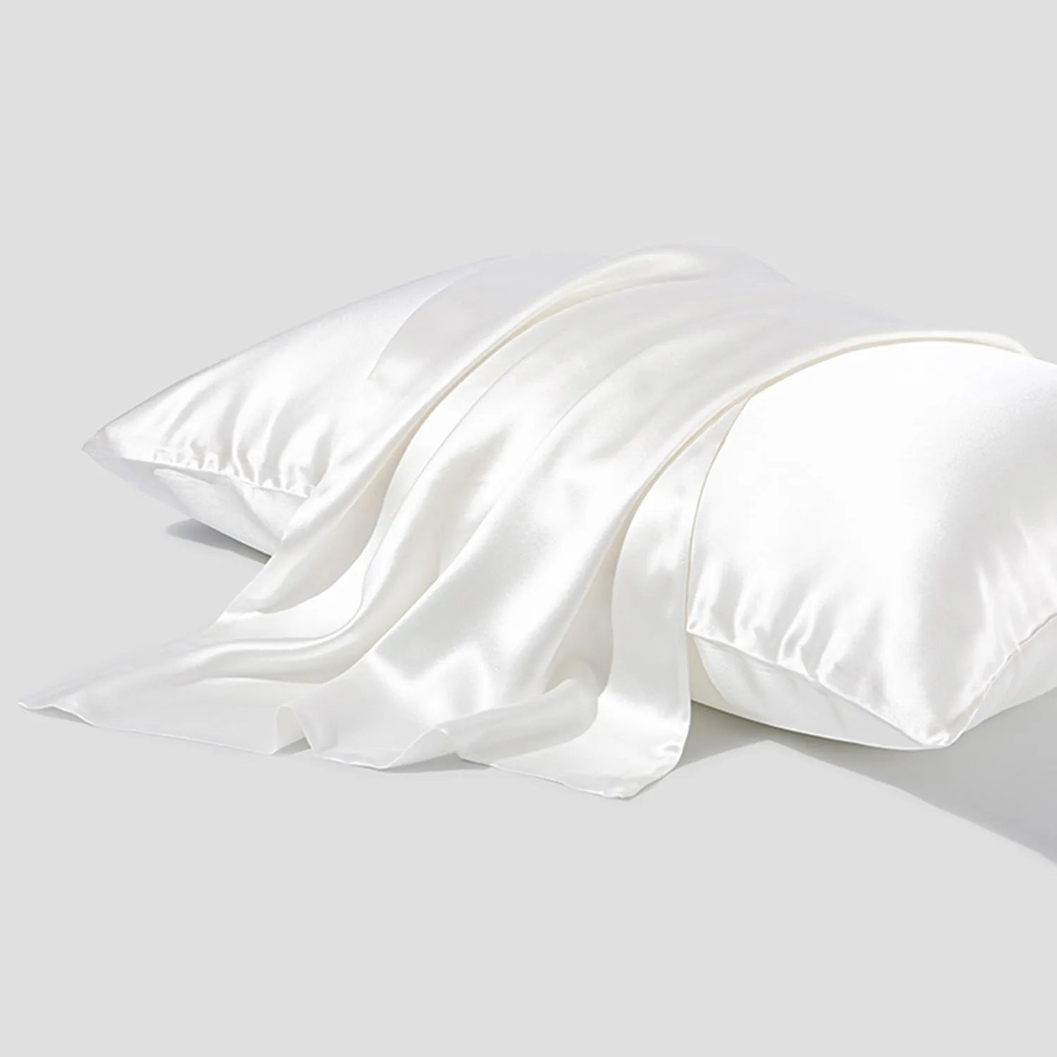 Dark grey mulberry silk pillowcase with an envelope closure on a bed.