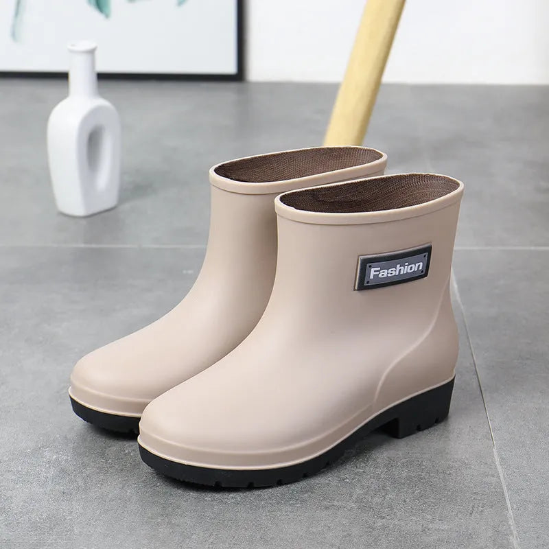 Women's mid-calf PVC rain boot in black on a wet surface.