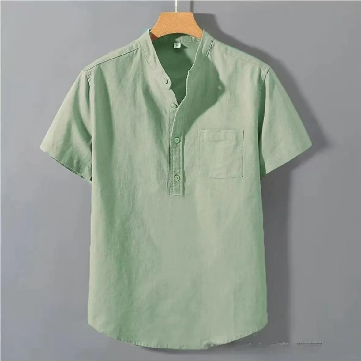 Man wearing a beige slub linen casual shirt with a stand collar and short sleeves, loose fit.