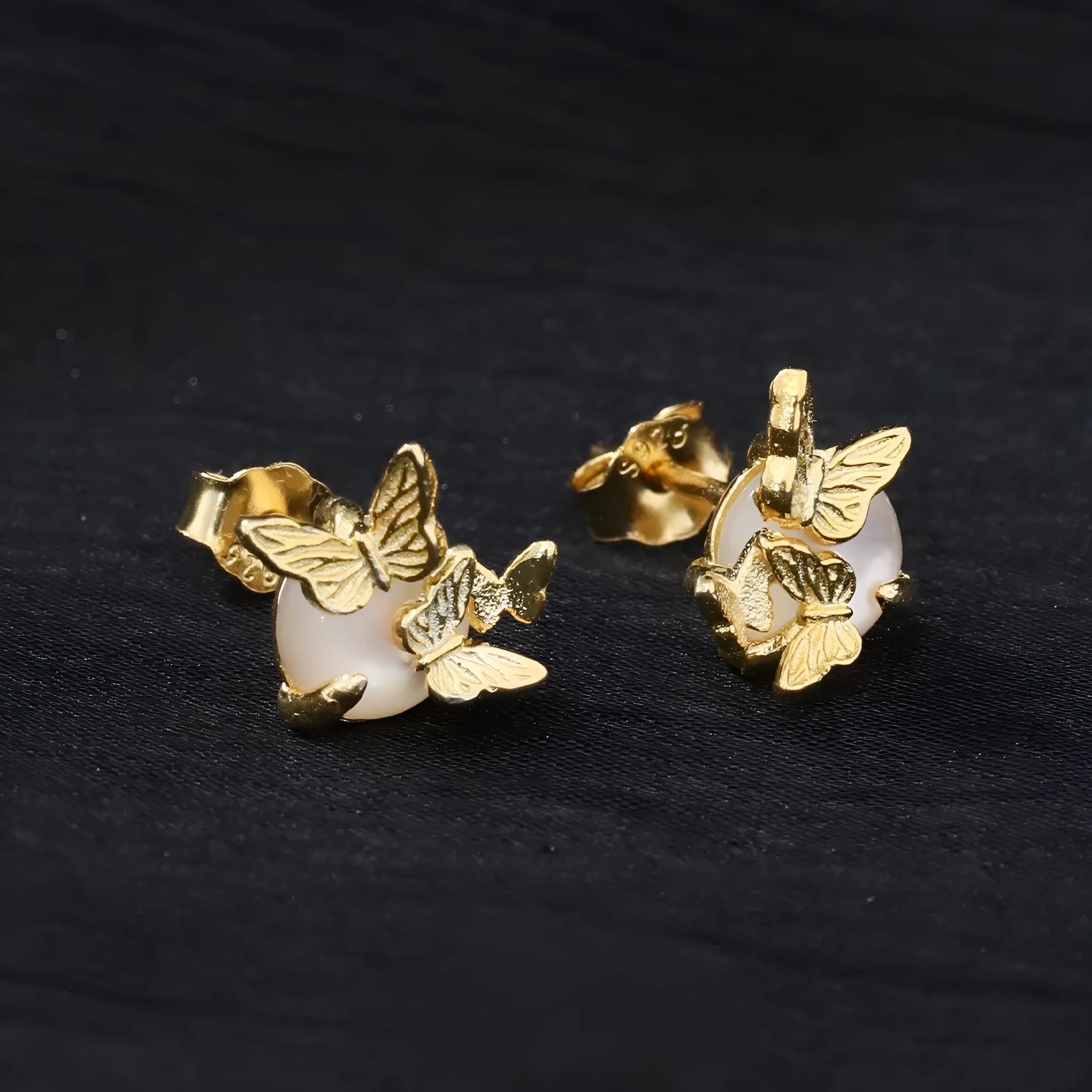 A pair of silver 925 butterfly stud earrings with an animal zodiac design in a gold colour finish.