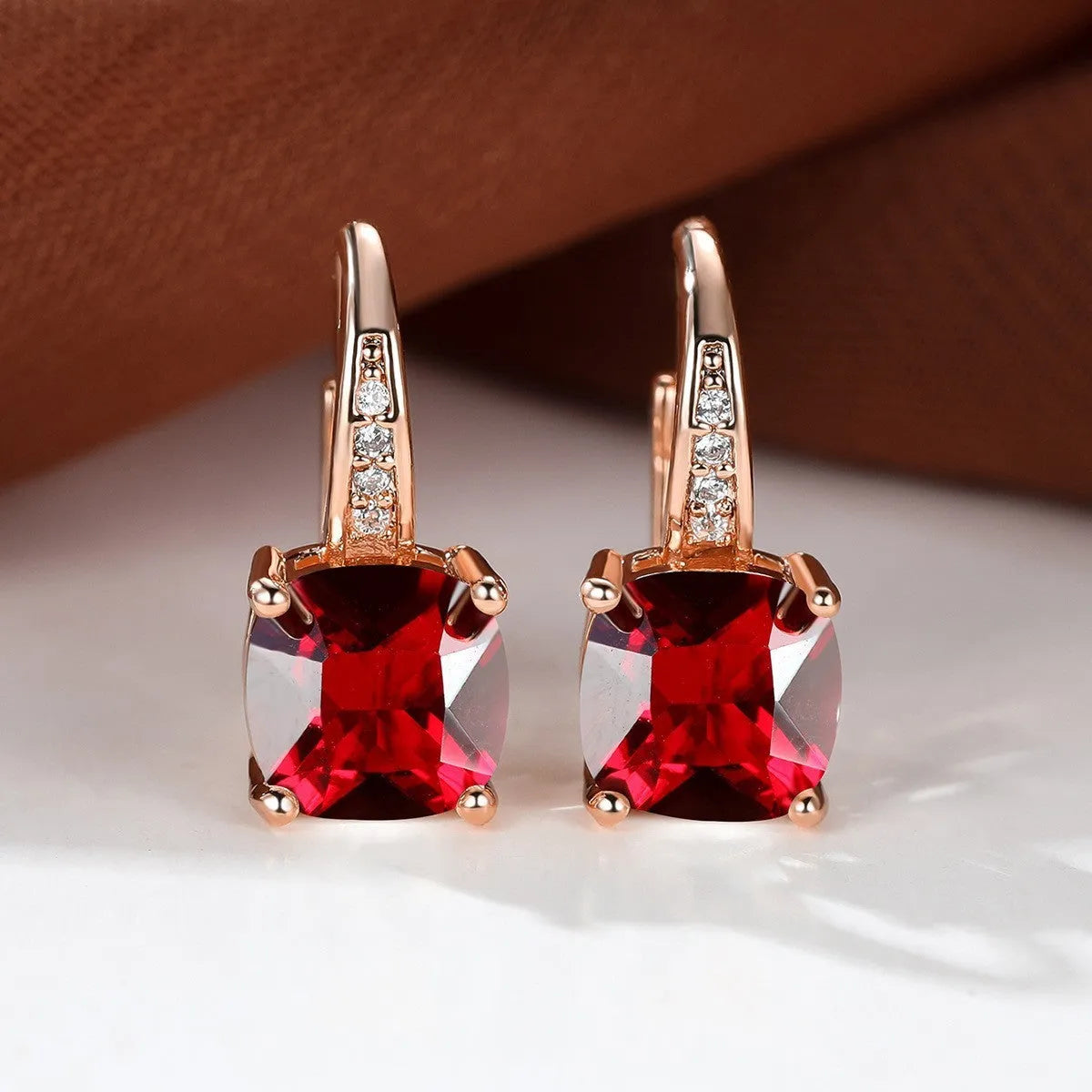 Square geometric ear hook earrings with zircon stones in an electroplated copper setting.