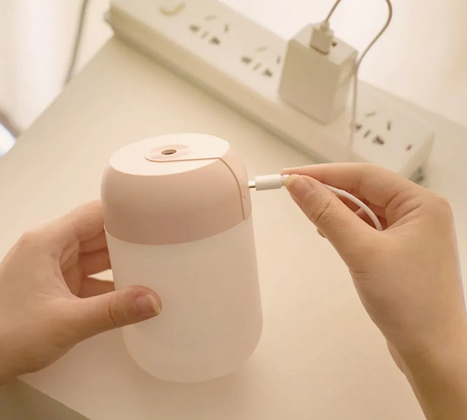 White cylindrical USB-powered mini humidifier with aromatherapy function on wooden desk