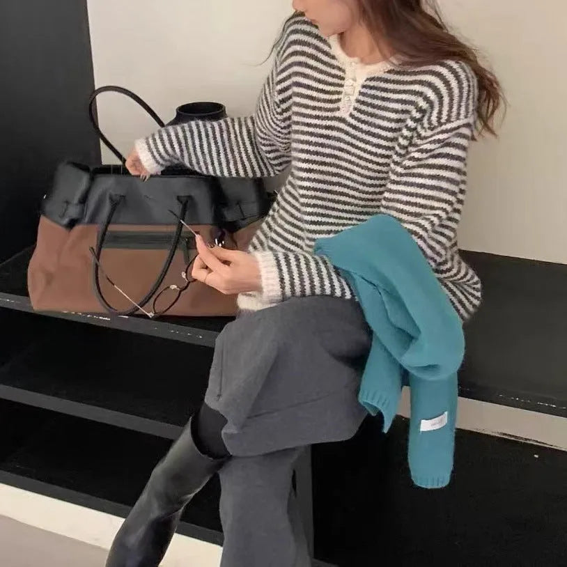 Red and blue striped women's cashmere pullover sweater on a hanger.