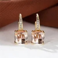 Square geometric ear hook earrings with zircon stones in an electroplated copper setting.