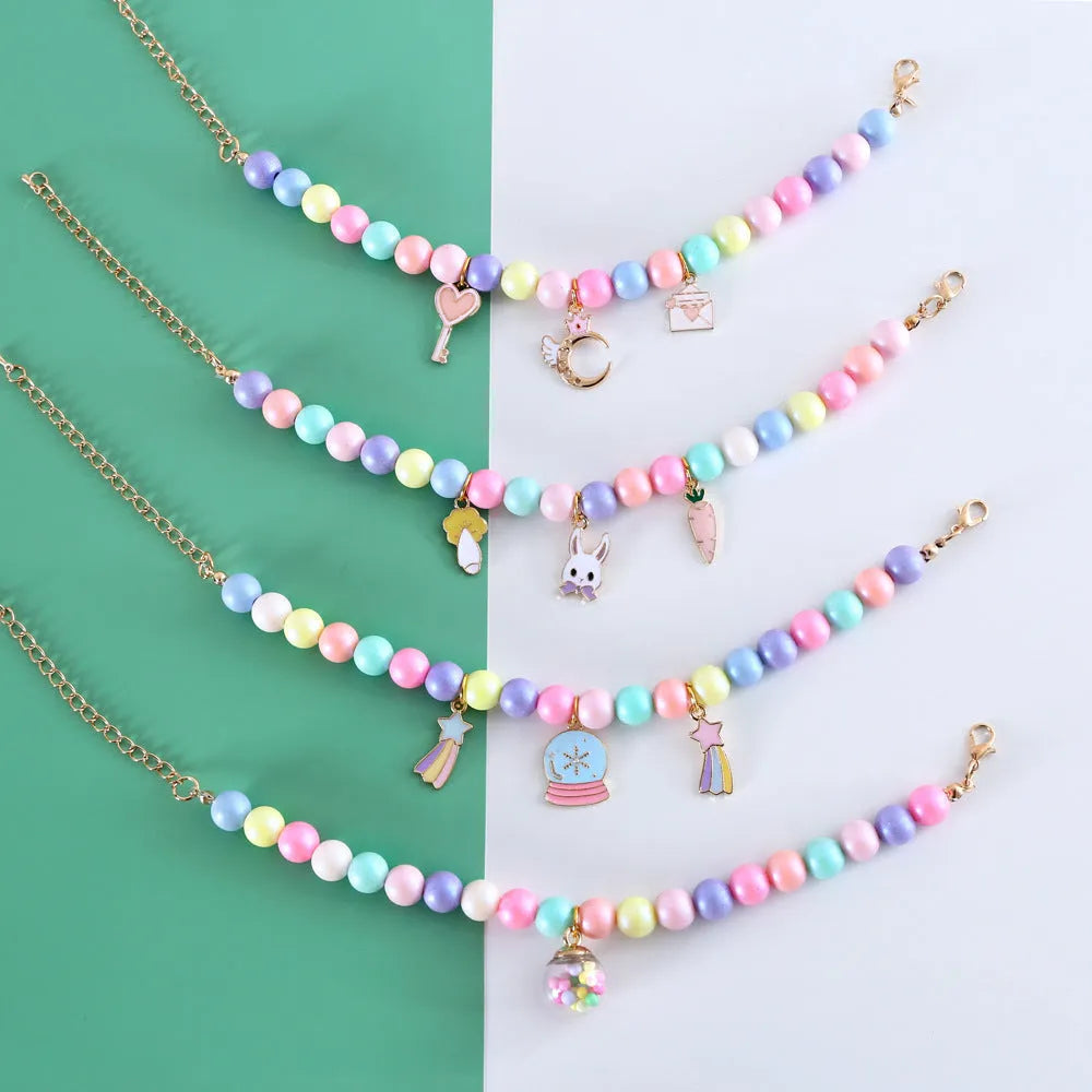 Macaron-coloured resin pet collar and bracelet set for birthday photoshoots on a neutral background.