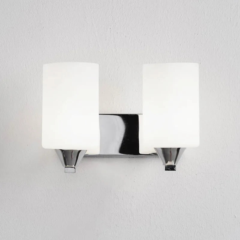 Modern chrome wall lamp with glass lampshade in single head configuration on white wall