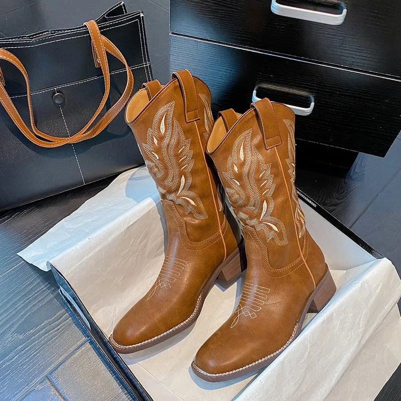 Brown women's mid-calf Martin boots with embroidered detail on the upper and a low square heel.