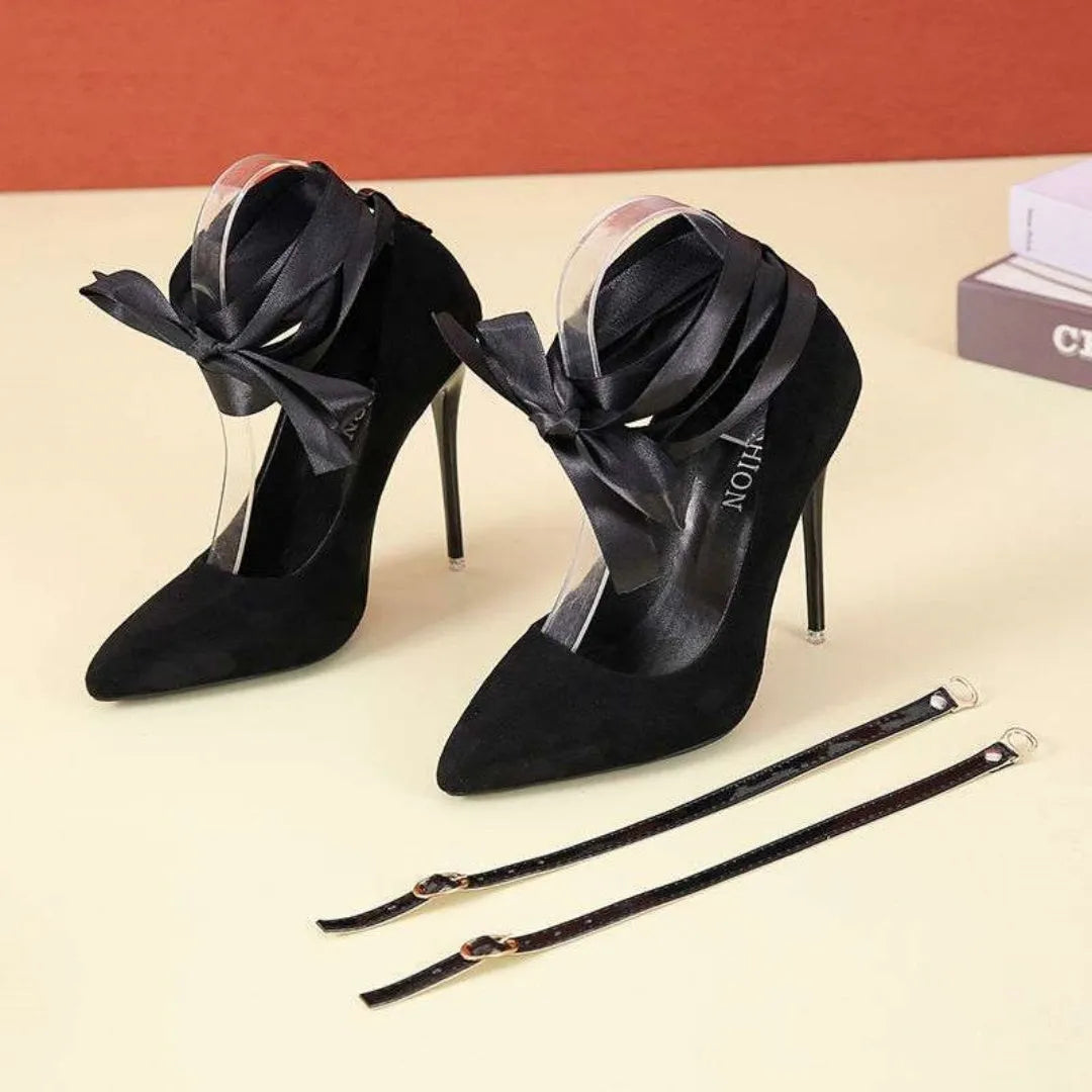 Black pointed toe stiletto shoe with shallow mouth design and a fabric strap with flat buckle