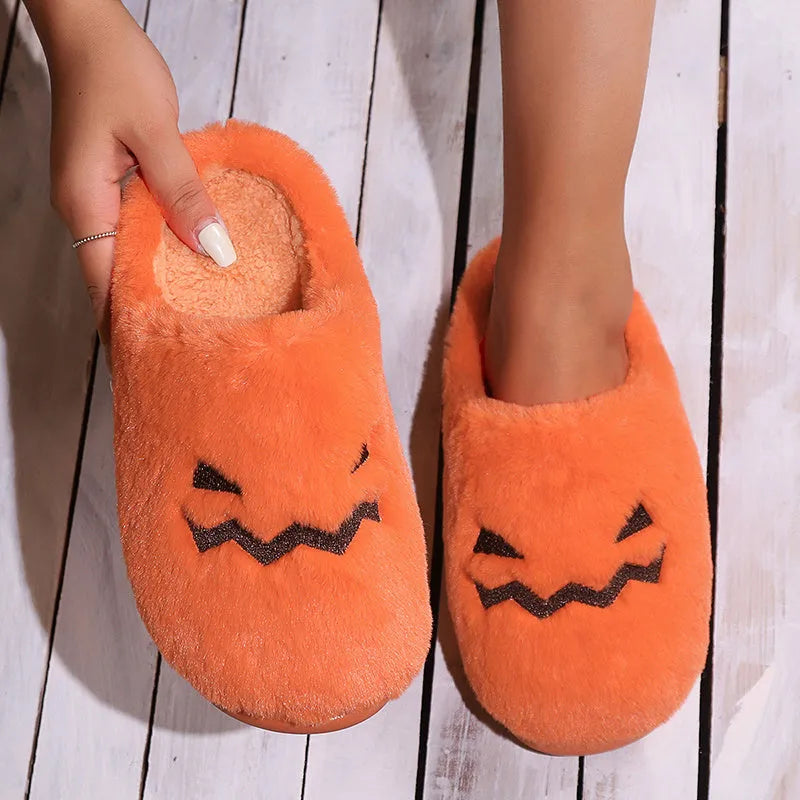 Orange Halloween pumpkin themed slippers with coral velvet upper and plush lining on a flat PVC sole.