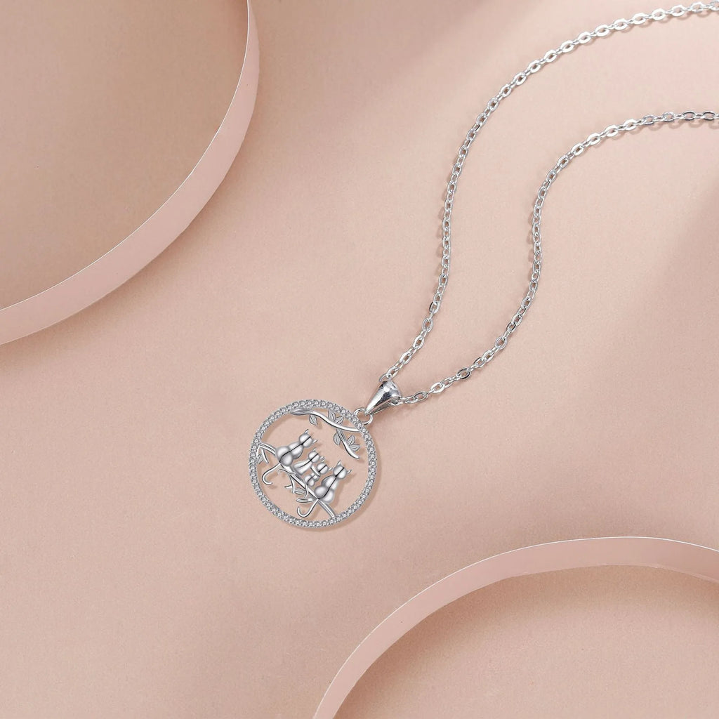 Copper necklace with four kitten pendants on a cross chain, electroplated finish.