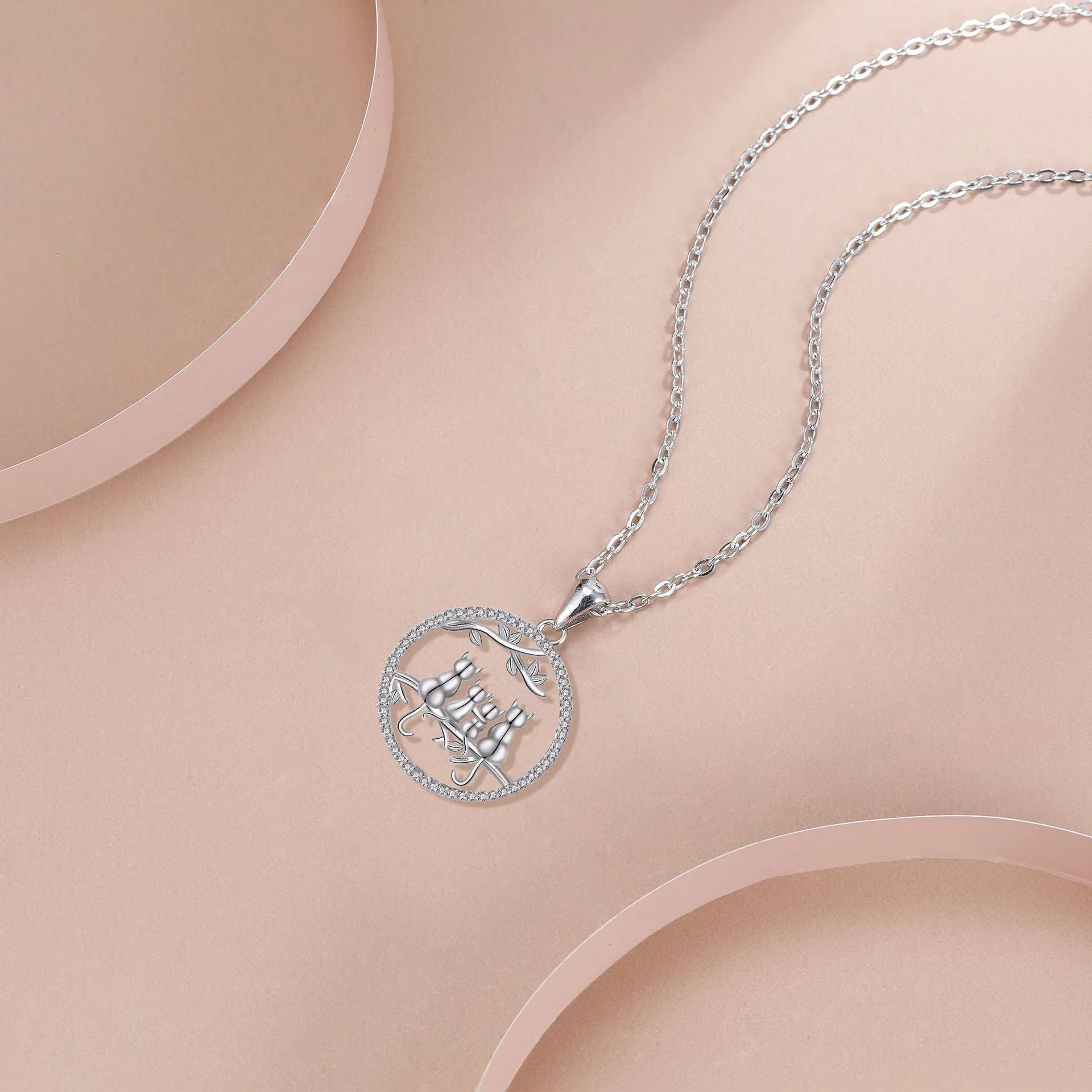 Copper necklace with four kitten pendants on a cross chain, electroplated finish.
