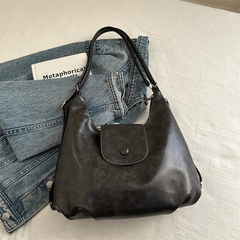 Women's textured PU leather shoulder bag with single strap and mobile phone compartment in black colour