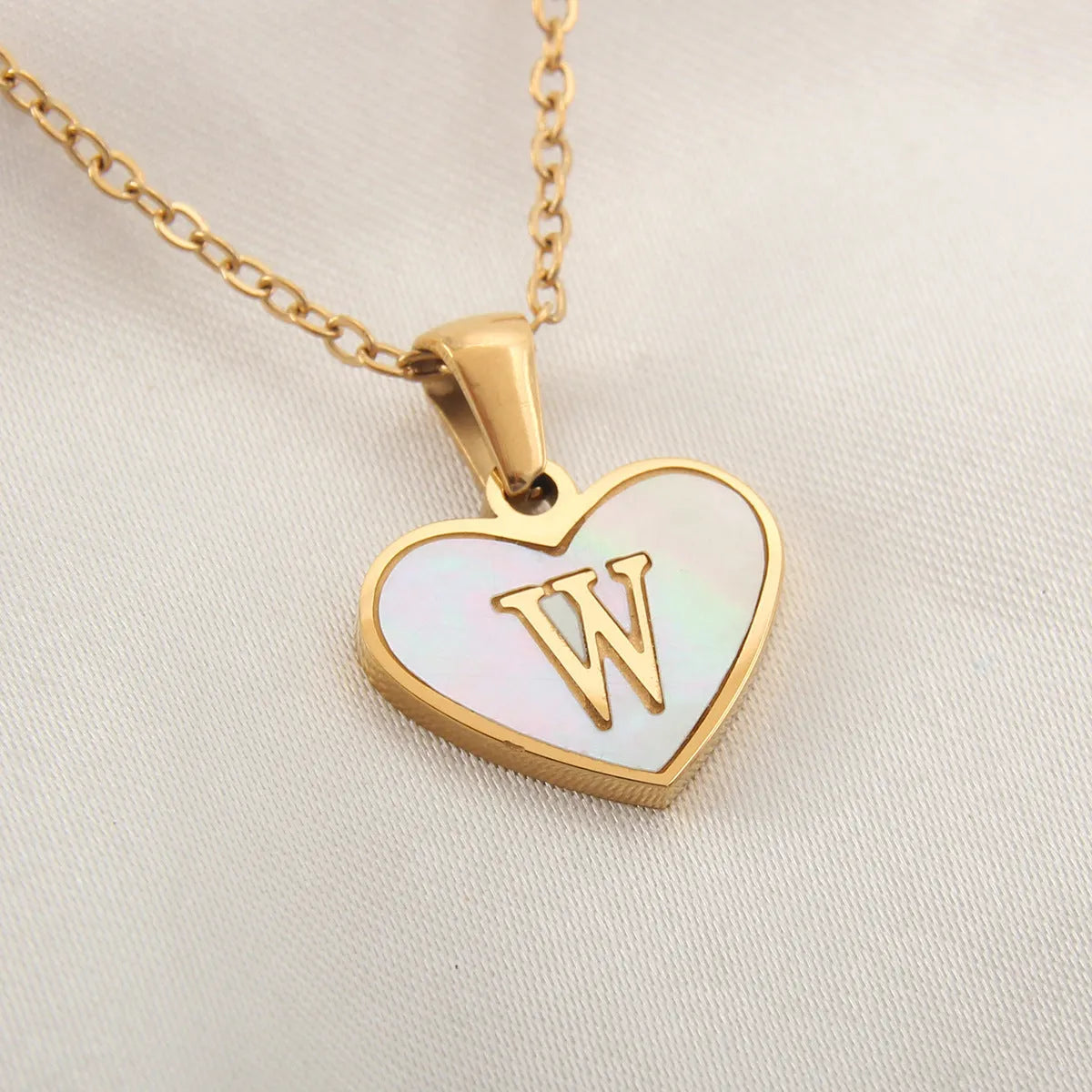 Gold plated heart-shaped personalised necklace with white shell charm on an adjustable chain.