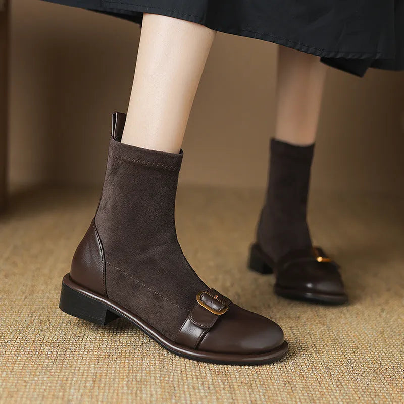 Black women's low heel Martin boot with belt buckle stitching and lace-up front on a rubber sole.