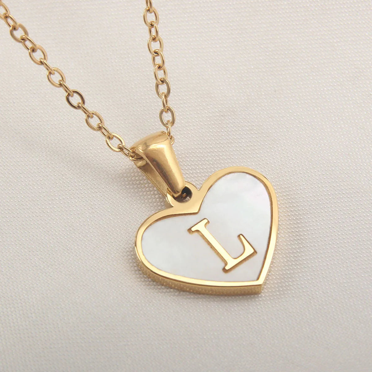 Gold plated heart-shaped personalised necklace with white shell charm on an adjustable chain.