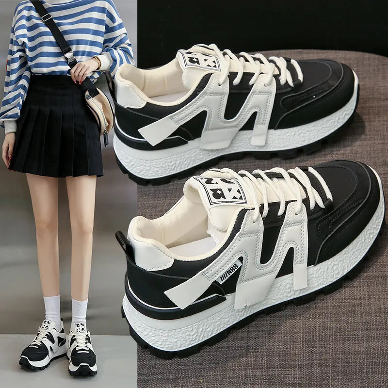 White and black unisex low-top sneakers with round toe and front lace-up on rubber sole