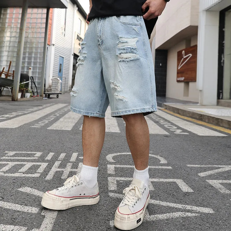Light blue ripped denim shorts with a loose, straight leg fit and distressed detailing.