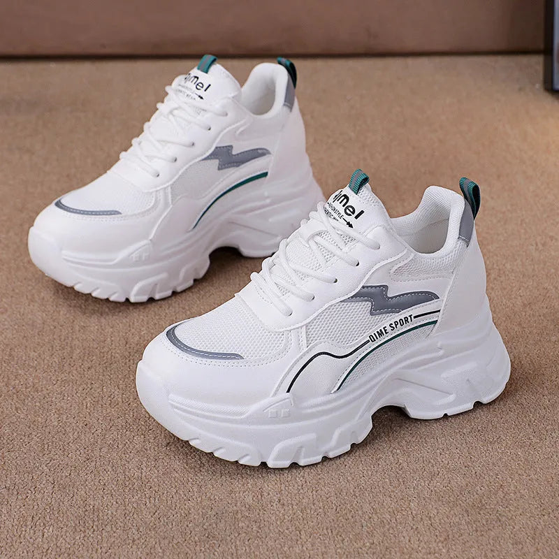 White women's low-top dad shoes with cross straps and lace-up front, showing round toe and rubber sole.