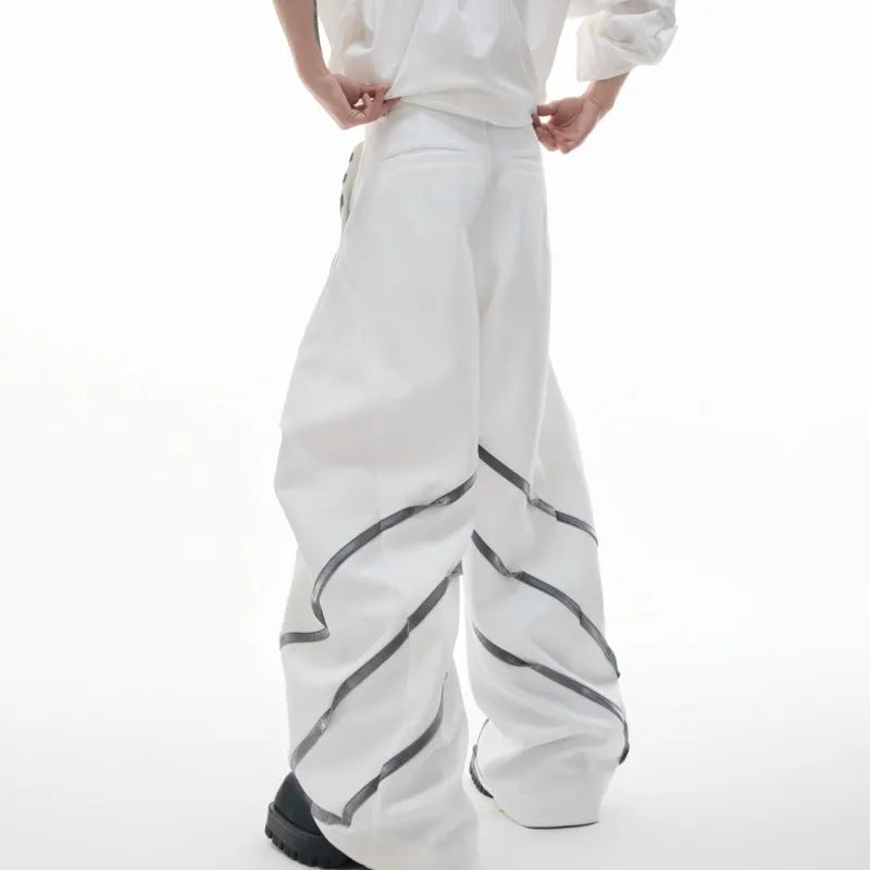 Men's black polyester trousers with front pleats and metal striped rivet details.