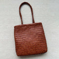 Brown handmade cowhide leather shoulder bag with woven tote design and three-dimensional pocket
