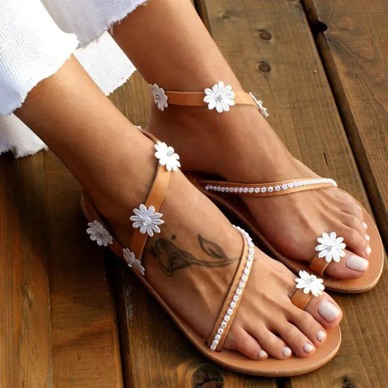 Brown women's flat sandals with floral pattern and herringbone toe on a rubber sole.