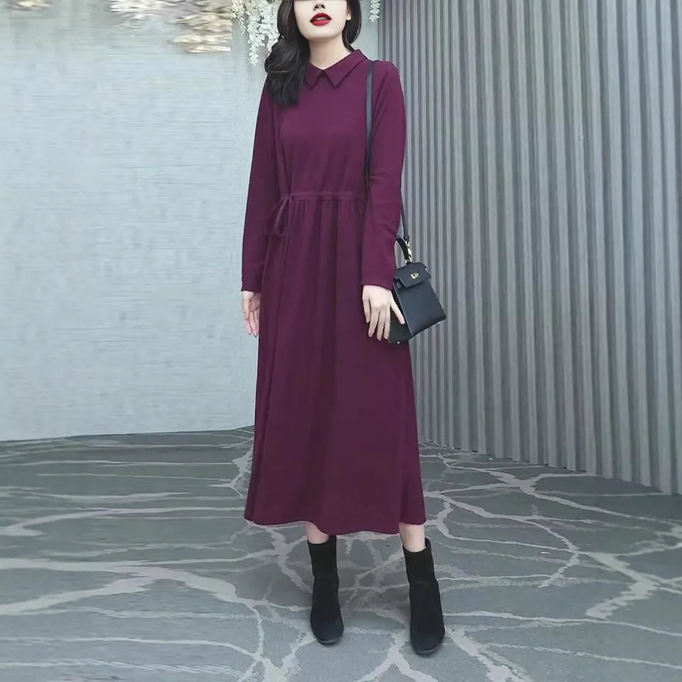 Purplish red plus size women's dress with long skirt and extra-long sleeves on a model.