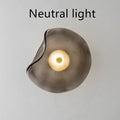 Round glass wall lamp for bedroom bedside in cognac, grey or light colour finishes.