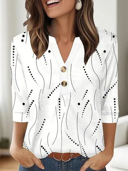 Woman wearing a loose V-neck T-shirt with a bold 3D pattern print in casual style.