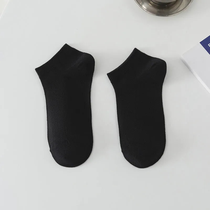 Solid colour low-cut polyester boat socks for men on a neutral background.
