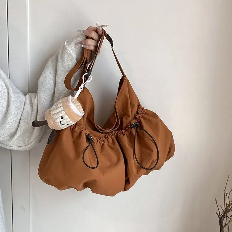 Ultra-light pleated foldable crossbody bag in soft polyester fabric, shown in green with split pockets.