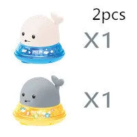 Whale-shaped electric bath toy spraying water with flashing lights, on a blue base.
