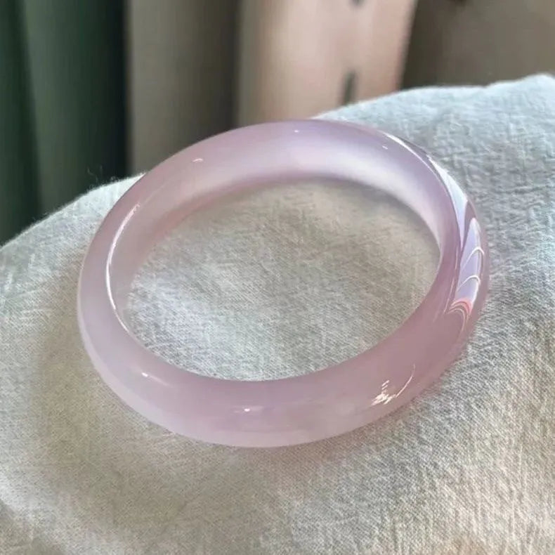 Natural agate wide tyre bracelet with cherry blossom jade accent on wrist, showing colour options.
