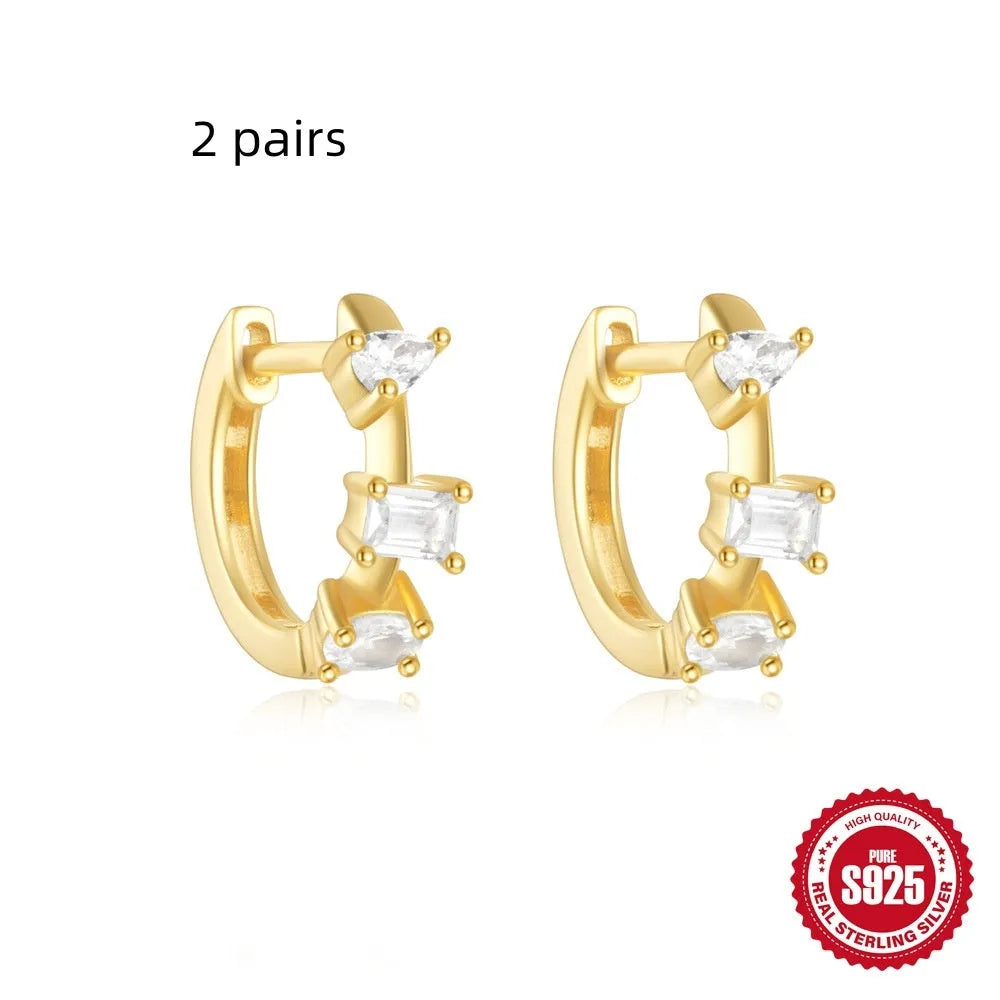 Sterling silver geometric stud earrings with a small round shape and classic diamond detail on a white background.