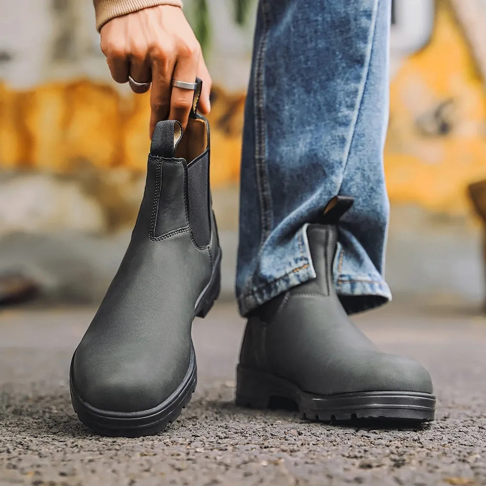 Vintage frosted brown leather Chelsea boot with round toe and low heel on a wooden surface.