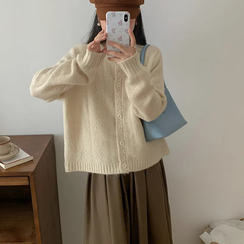 Loose apricot-coloured retro-style knit cardigan coat on a hanger