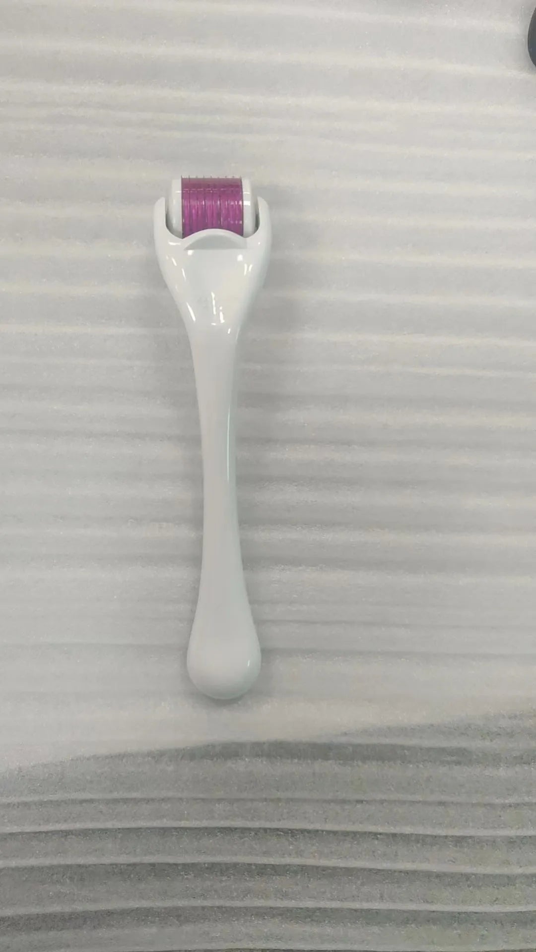 Black handle micro needle roller with purple wheel showing 540 stainless steel needles for dermaplaning