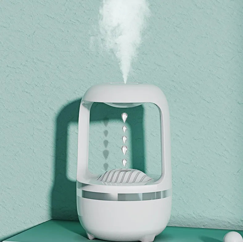 Black or white anti-gravity humidifier with water droplet effect on a desk.