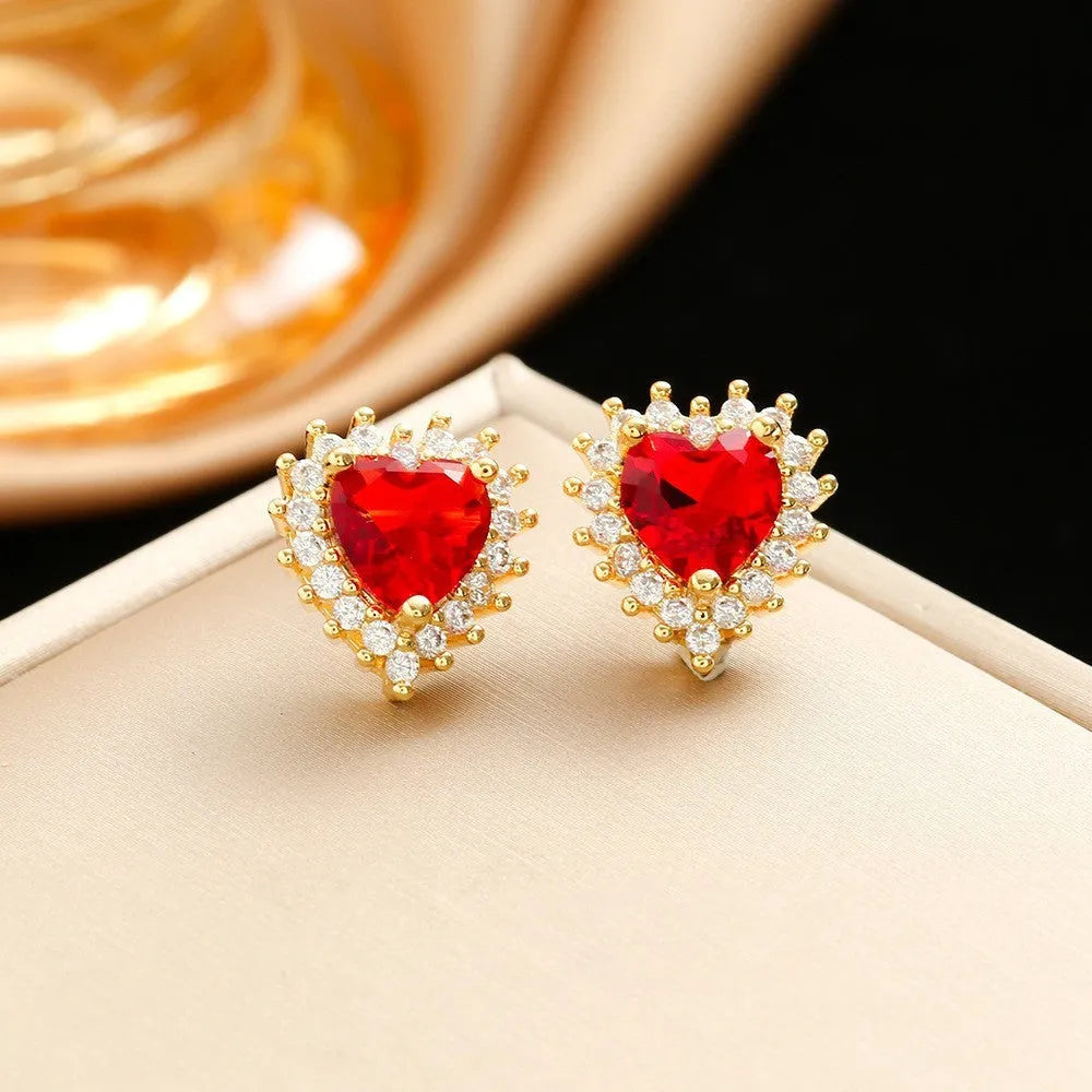 Gold red titanium steel jewellery set with heart flower pendant, matching earrings, and ring on a water wave chain.