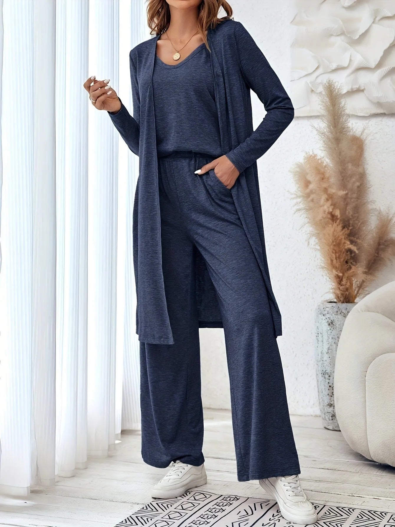 Blue women's two piece casual suit with long sleeve top, trousers, and suspenders on a hanger.