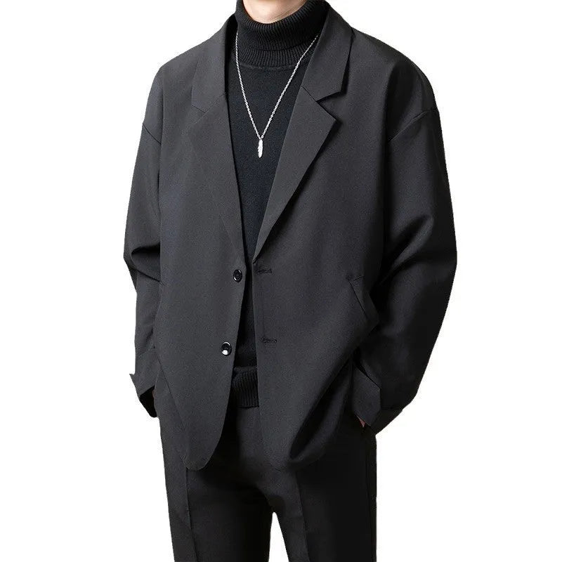 A man wearing a loose-fit casual suit jacket in a light colour, suitable for smart-casual occasions.