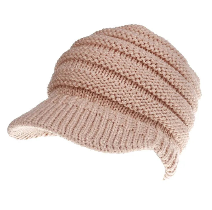 Woman wearing a soft knitted beanie with a ponytail pulled through the hole at the back.