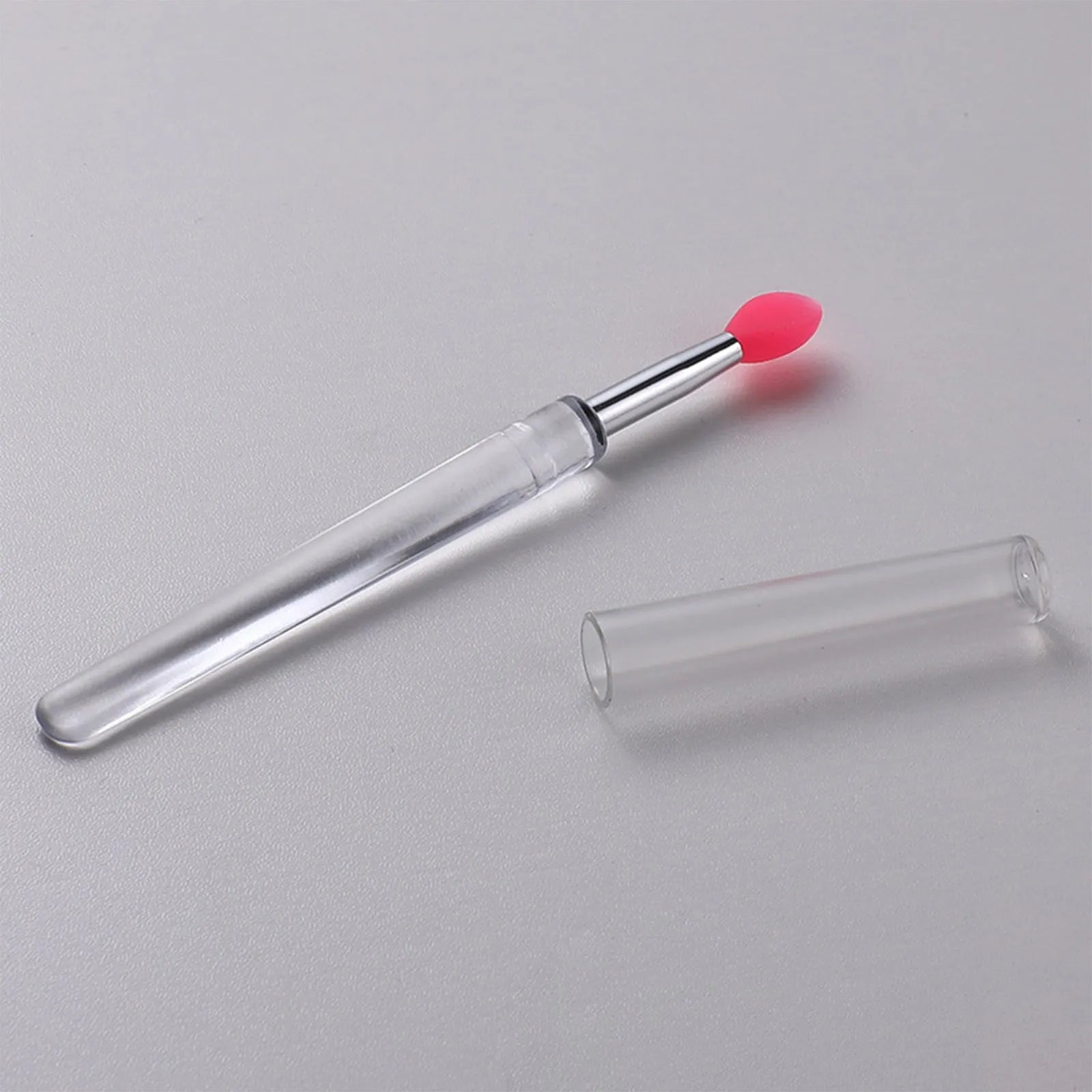 Set of coloured silicone lip brushes with protective caps for applying lipstick and lip gloss.