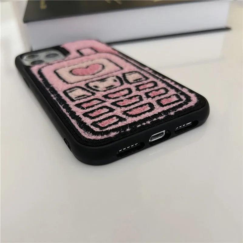 Pink TPU iPhone case with a towel-embroidered pattern, shown fitting an iPhone model.