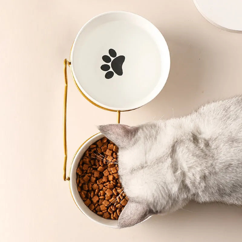 White ceramic cat bowl with cat paw print pattern in a black iron cat-ear frame