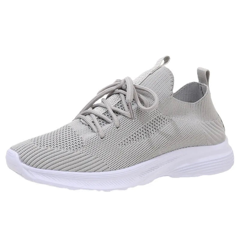 Women's low-top running shoes with mesh lining and Flyknit upper in creamy white, grey, or orange colours
