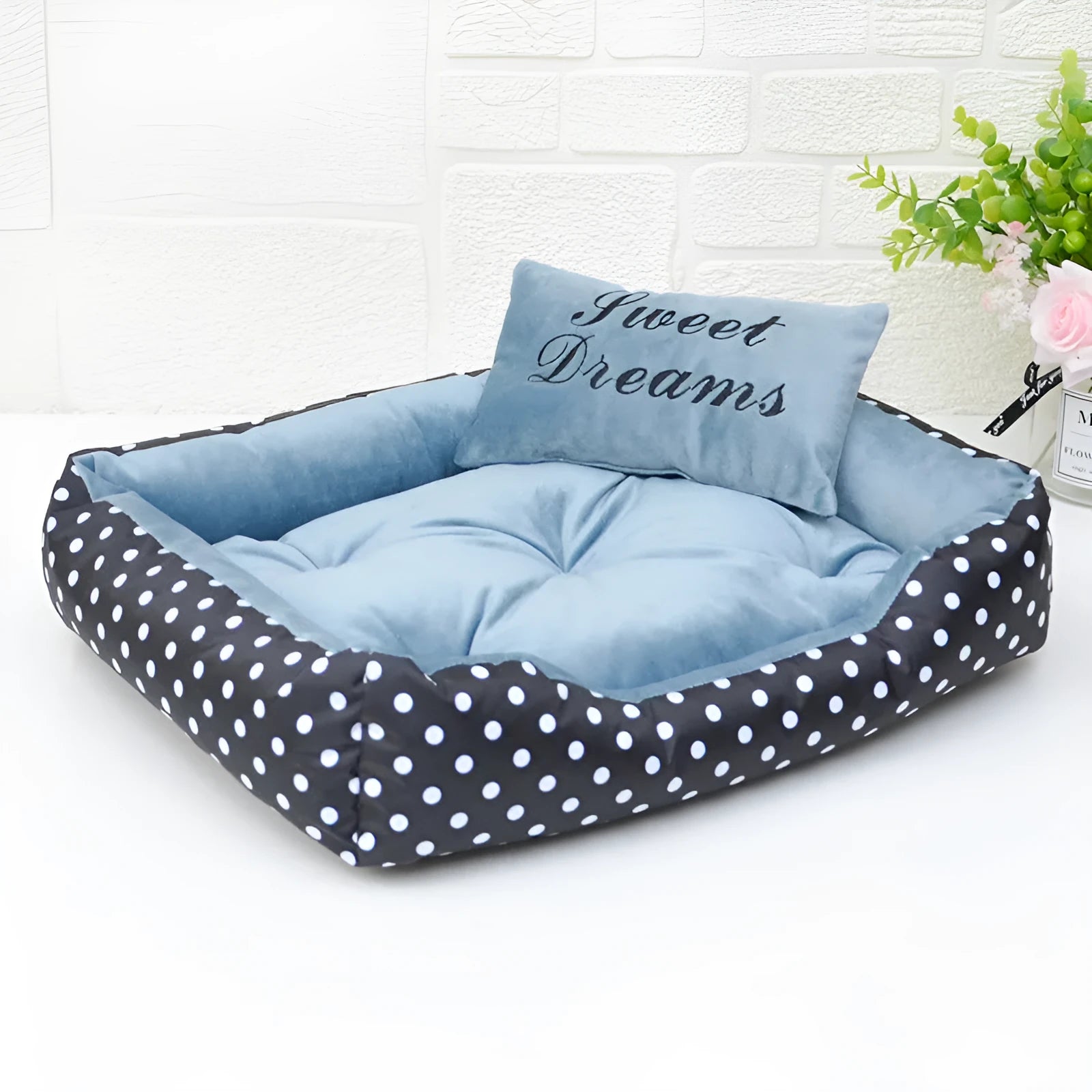 Polka dot print square dog bed with raised sides and a matching embroidered pillow in grey.