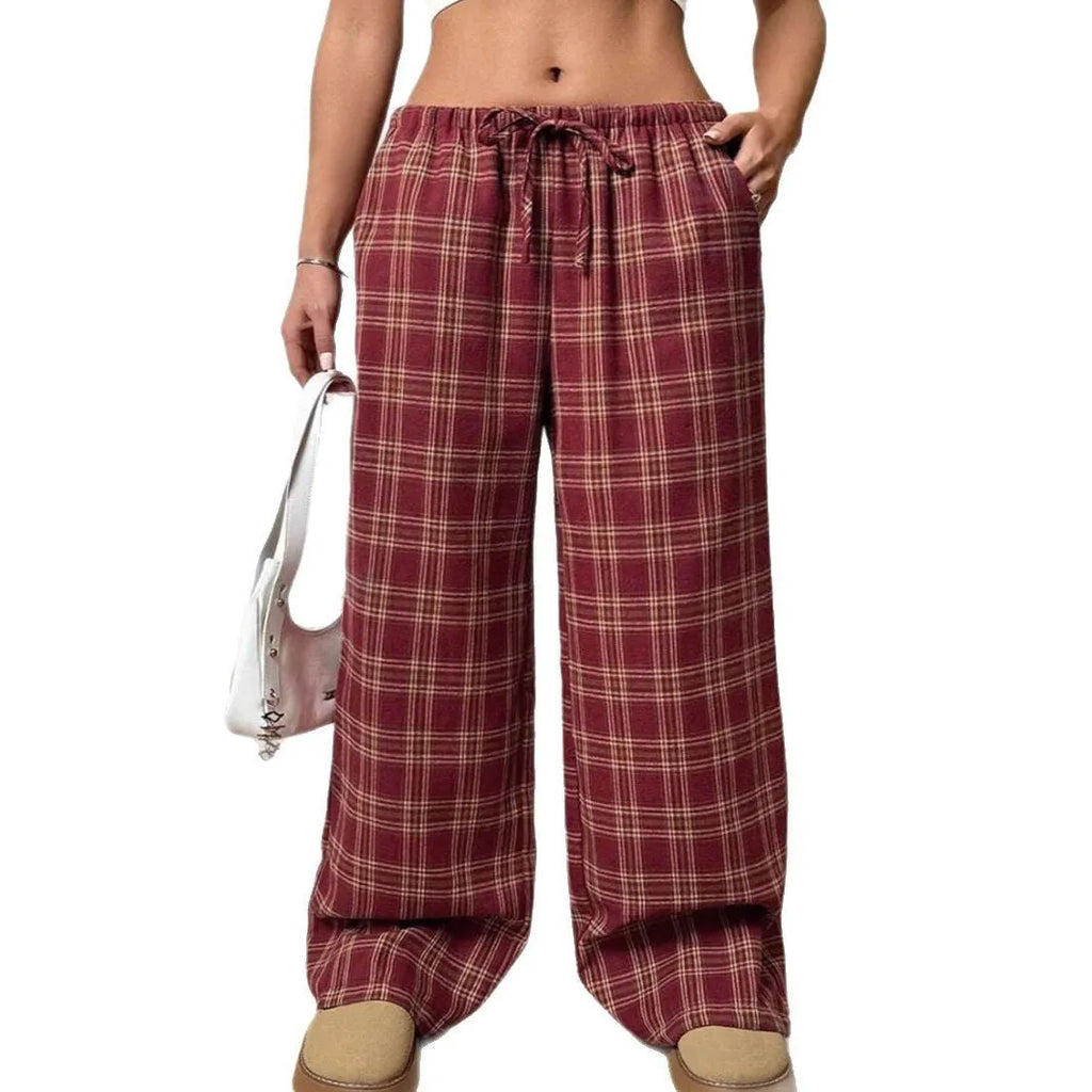 Red women's loose fit plaid trousers with drawstring waist and pockets on a mannequin.