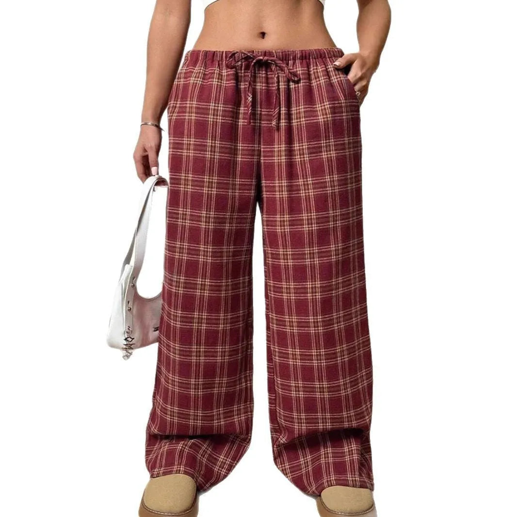 Red women's loose fit plaid trousers with drawstring waist and pockets on a mannequin.