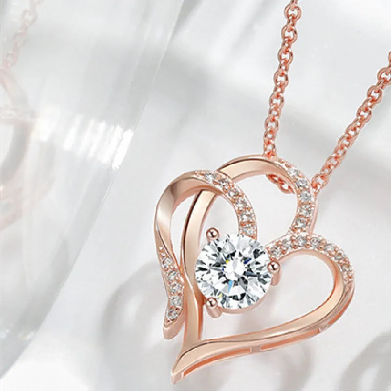 Close-up of a women's heart-shaped pendant necklace in 925 silver with a choice of gold tone finishes.