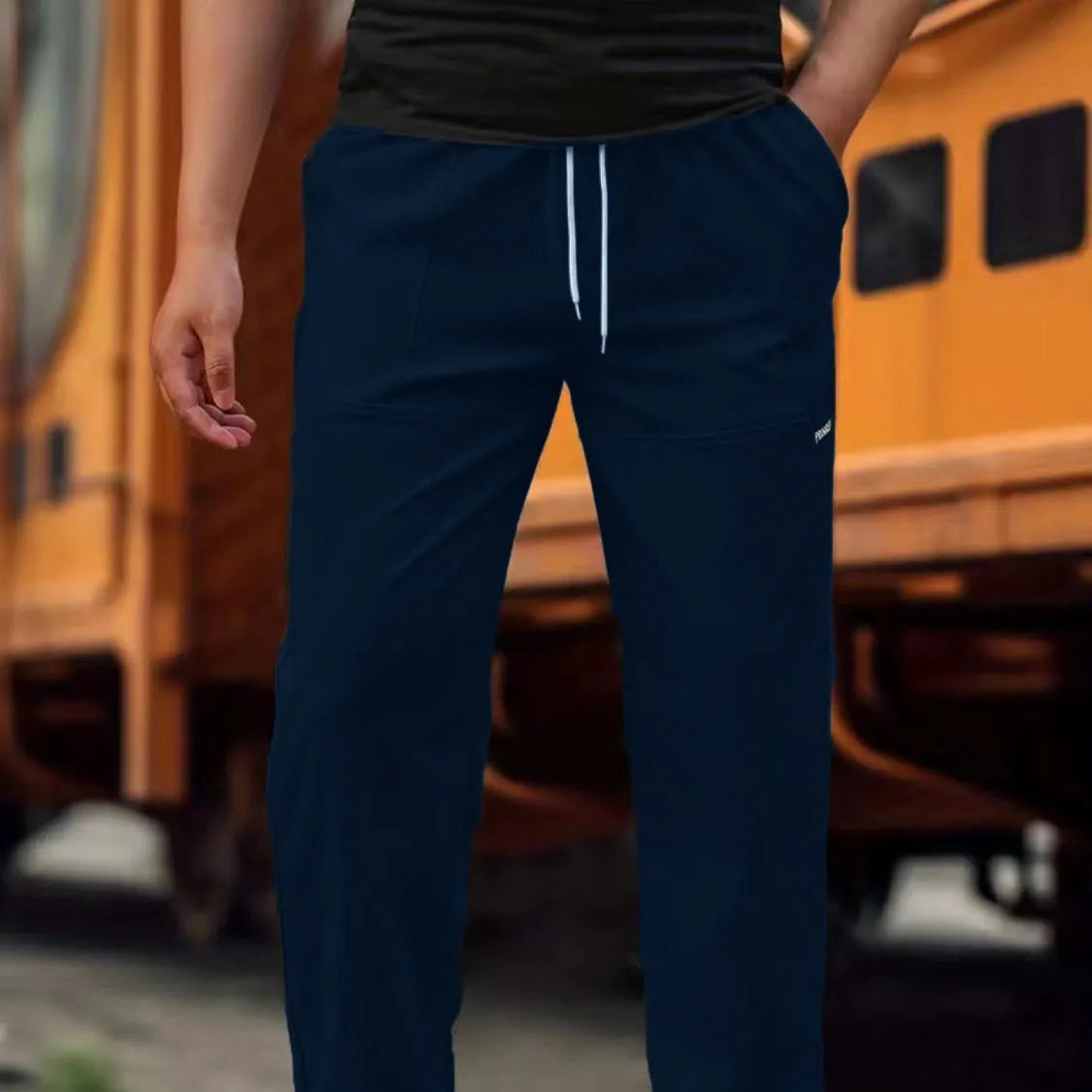 Men's polyester trousers in light grey, shown laid flat, suitable for spring and autumn wear.